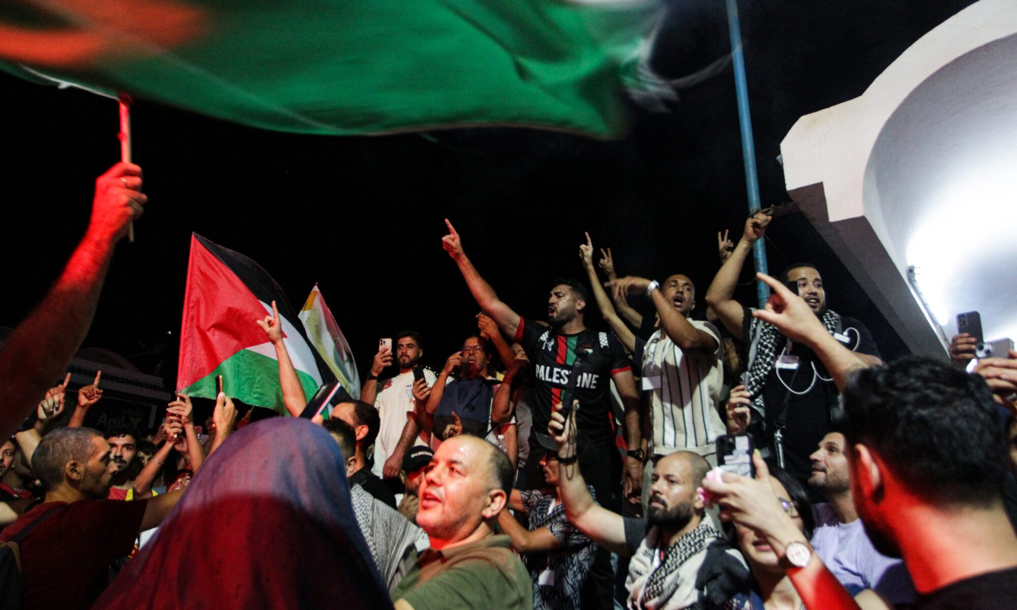Tunisian protesters shout anti-Israeli slogans and wave Palestinian flags at the Port of Sidi Bou Said near Tunis on September 9, 2025, after the organisers of a Gaza-bound flotilla carrying humanitarian aid and pro-Palestinian activists said late on September 8 that one of their boats was hit by a suspected UAV but Tunisian authorities said