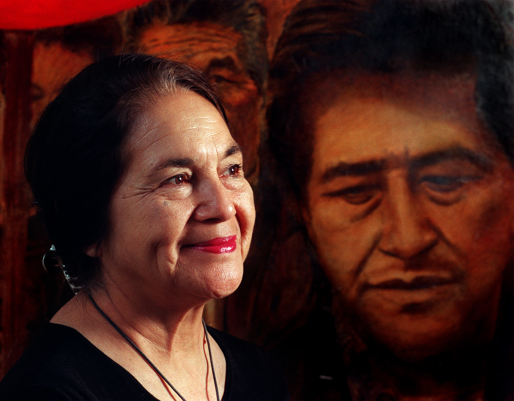 Delores Huerta at United Farm Workers Headquarters at La Paz, near Keene and Tehachpi. Photo taken on June 14, 1999. ^^^ Portrait of Dolores Huerta in front of a painting with Cesar Chavez and farmworkers. Artist unknown. (Photo by Annie Wells/Los Angeles Times via Getty Images)