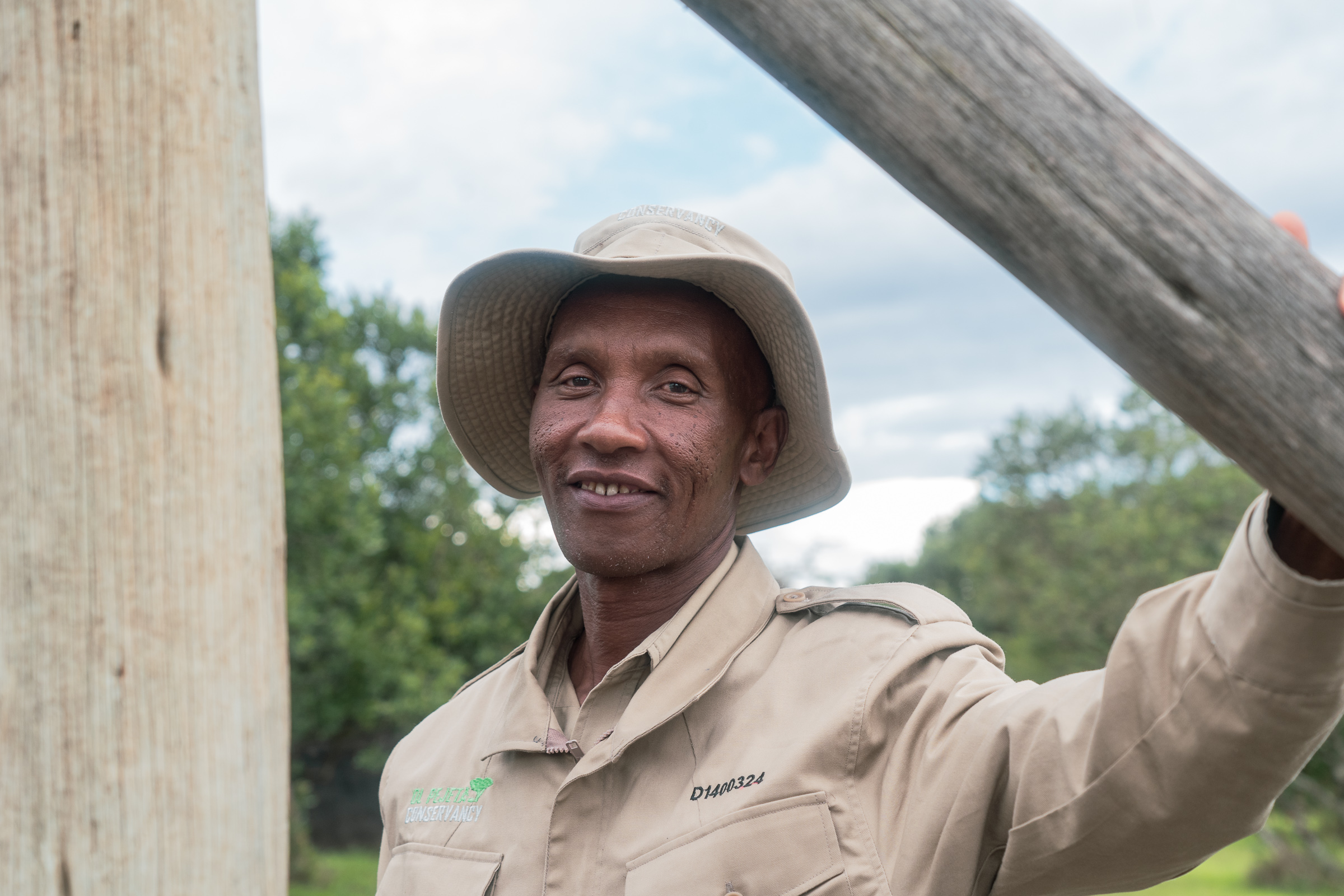 Timothy Njuguna, 52, has worked at Sweetwaters since 1995. Years ago, when a group of chimpanzees broke loose and pinned him to the floor of the holding house, Kiza — whom he had cared for since infancy — fought the others off and gave him a chance to escape. Photo by Jaclynn Ashly.